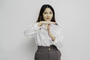 Hispanic Asian woman wearing white shirt doing time out gesture with hands, frustrated and serious face photo