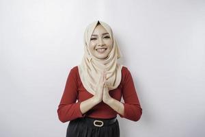 Portrait of a young beautiful Muslim woman wearing a hijab gesturing Eid Mubarak greeting photo