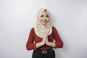 retrato de una joven y hermosa mujer musulmana que usa un hiyab haciendo un gesto de saludo de eid mubarak foto