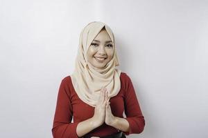 retrato de una joven y hermosa mujer musulmana que usa un hiyab haciendo un gesto de saludo de eid mubarak foto