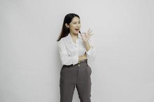 Excited Asian woman giving an OK hand gesture isolated by a white background