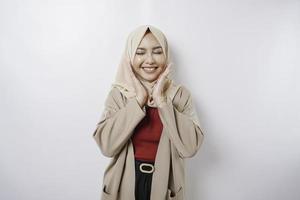 Portrait of a confident smiling Asian Muslim woman standing and looking at the camera isolated over white background photo