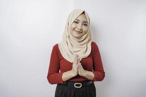 Portrait of a young beautiful Muslim woman wearing a hijab gesturing Eid Mubarak greeting photo