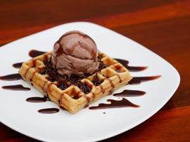 chocolate waffle with ice cream topping and chocolate sprinkles photo