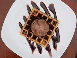 chocolate waffle with ice cream topping and chocolate sprinkles photo