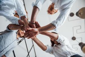 View from below. Successful business people putting their hands together photo