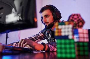 Portrait of young bearded pro gamer playing in online video game photo