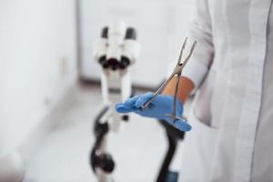 Close up view of female doctor hands that holds forceps photo