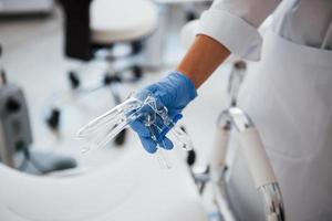 Close up view of female doctor hands that holds speculum instrument photo