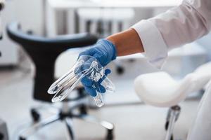 Close up view of female doctor hands that holds speculum instrument photo