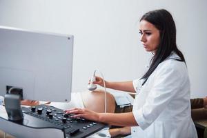 Female doctor does ultrasound for a pregnant woman in the hospital photo