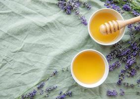 tarro con miel y flores frescas de lavanda foto