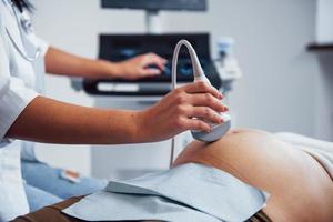 Female doctor does ultrasound for a pregnant woman in the hospital photo