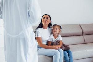 Mother with her cute daughter is visiting clinic. Listening to the doctor photo