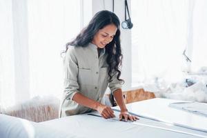 Beautiful female worker is in the sewing factory at daytime photo