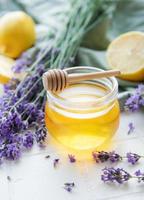 tarro con miel y flores frescas de lavanda foto