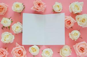 Pink and white roses put on pink background with empty white card for Valentine day. Flat lay background concept. photo