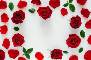 Red roses with its petals and leaves put on white background with heart shape space for Valentine day. Flat lay background concept. photo