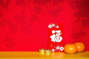 Red envelope packet or ang bao word mean wealth, sentence mean may all go well, great fortune and profit puts with oranges and ingots. photo