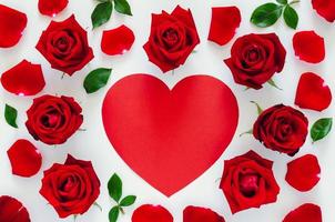 Red roses with its petals and leaves put on white background with red heart shape space for Valentine day. Flat lay background concept. photo