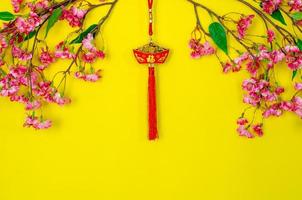 colgante colgante para adorno de año nuevo chino significado de palabra es riqueza con flores chinas sobre fondo amarillo. foto