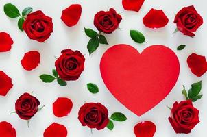 Red roses with its petals and leaves put on white background with red heart shape space for Valentine day. Flat lay background concept. photo