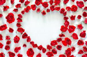 rosas rojas puestas en tela satinada blanca con espacio vacío de fondo de forma de amor para el concepto de aniversario y día de san valentín. foto