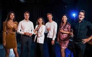 Group of friends in festive clothes have party indoors together photo