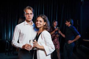 retrato de una pareja encantadora que tiene una fiesta junto con sus amigos foto