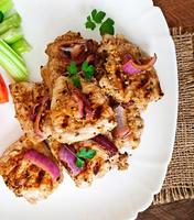 Sliced pork grilled with vegetables on ceramic brown plate. photo