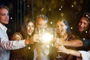 Group of cheerful young people have party and celebrating new year indoors photo