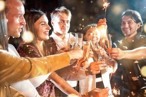 Group of cheerful young people have party and celebrating new year indoors photo