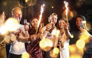 Group of cheerful young people have party and celebrating new year indoors photo