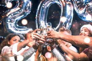 Positive young people holds balloons with new 202 year and celebrating photo