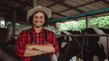 granjeros sonrientes y felices en la granja lechera. industria agrícola, concepto de agricultura y ganadería, vaca en una granja lechera comiendo heno. foto