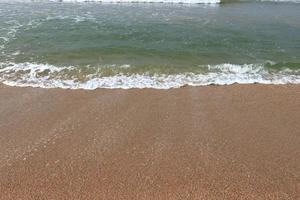 ola en el fondo de la playa de arena foto