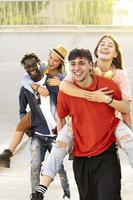 Two couples having fun piggybacking at sundown photo