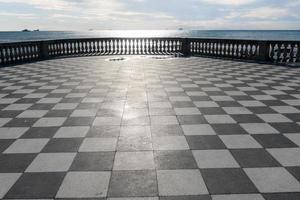 livorno, italia-27 de noviembre de 2022-terraza mascagni, una espléndida terraza belvedere con superficie pavimentada de tablero de ajedrez, livorno, toscana, italia durante un día soleado. foto