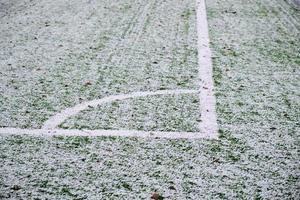 football field, lawn under snow, first snow on grass, football field markings photo