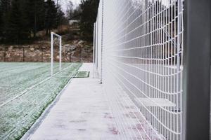 campo de fútbol, césped bajo la nieve, primeras nevadas en el césped, marcas de campo de fútbol, red en el campo de deportes foto