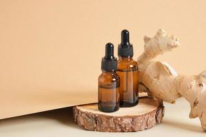 amber glass dropper bottles and ginger root on beige background copy space natural cosmetic concept photo