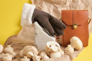 gloves and champignons on a yellow background, vegan leather concept photo