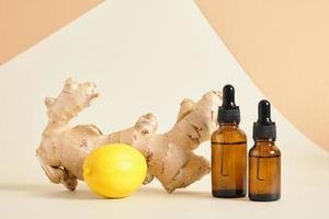 lemon, amber glass dropper bottles and ginger root on beige background copy space natural cosmetic concept photo