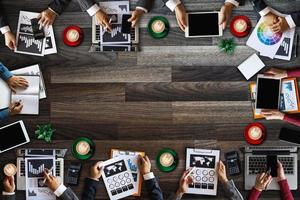 Top view of business Group of Multiethnic Busy People meeting with other in modern office with laptop computer, smartphone, tablet, coffee and document on table. photo