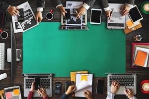 Top view of business Group of Multiethnic Busy People meeting with other in modern office with laptop computer, smartphone, tablet, coffee and document on table. photo