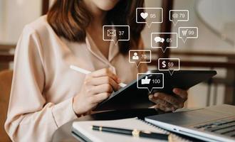 Social media and Marketing virtual icons screen concept.close up of businesswoman typing keyboard tablet with laptop computer photo