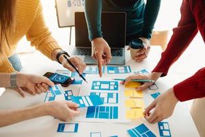 UX developer and ui designer brainstorming about mobile app interface wireframe design with customer breif and color code at modern office. photo
