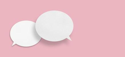 Round white paper with speech bubbles isolated on pink background communication bubble . photo