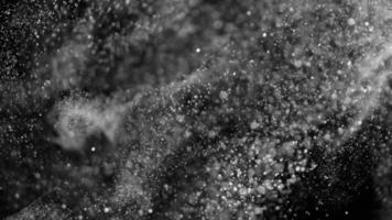 Slow movement of microparticles in the form of small and rounded bubbles on a black background video