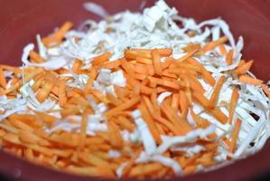 Shredded white cabbage with grated carrots in a basin photo